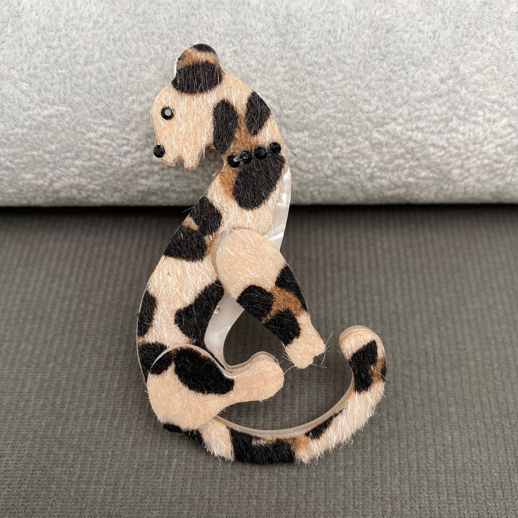 Cheetah print brooch on a gray background
