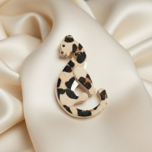 Cheetah print brooch on a cream satin background