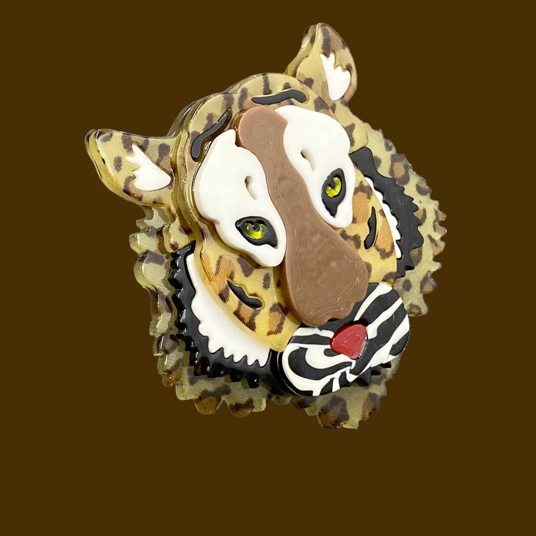 Tiger print brooch with a layered dimensional face design on a brown background
