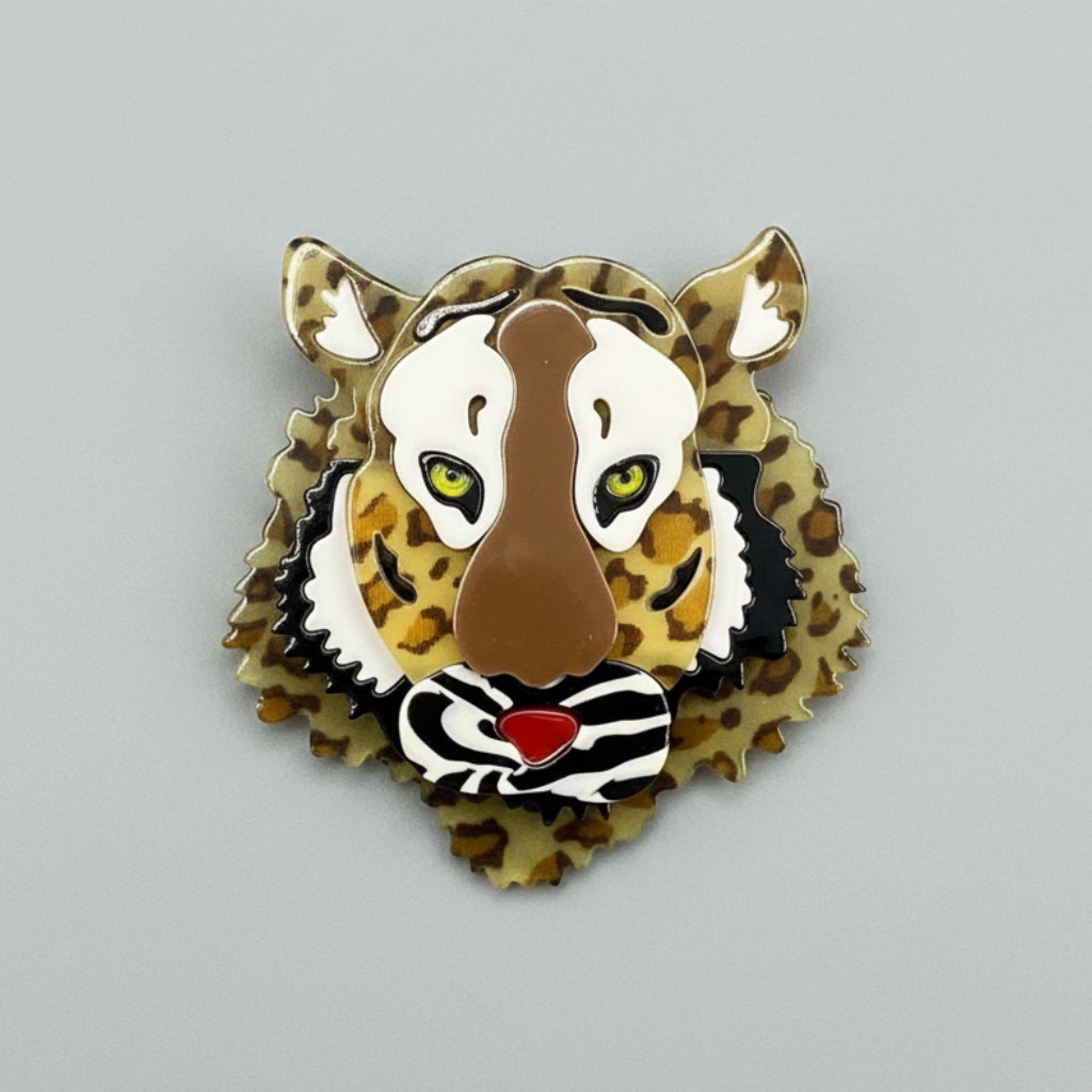 Tiger print brooch with a layered dimensional face design on a gray background