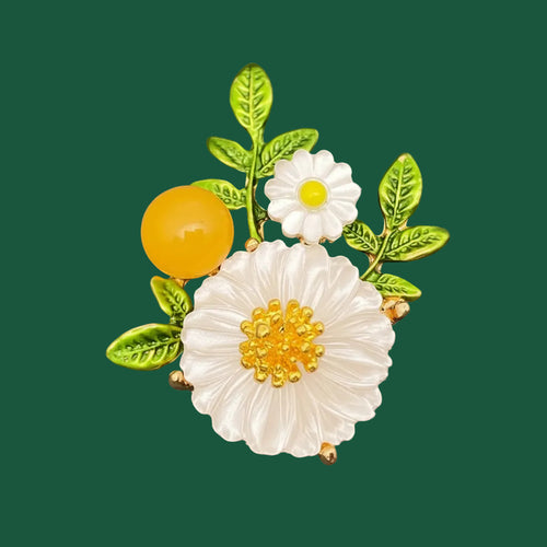 Floral brooch with white flowers, green leaves, and a yellow berry on a green background