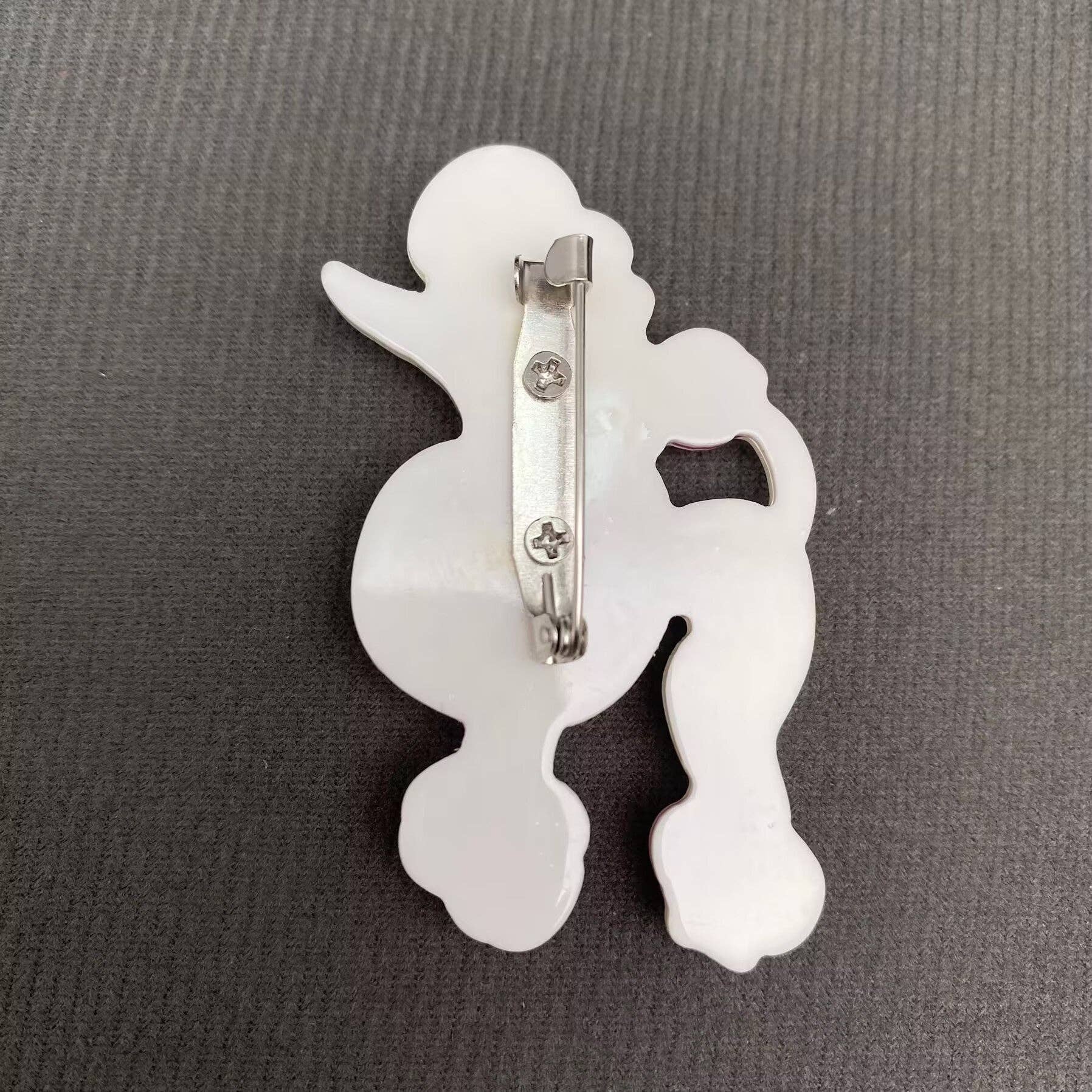 Back view of the pink and white poodle-shaped brooch showing the clasp mechanism