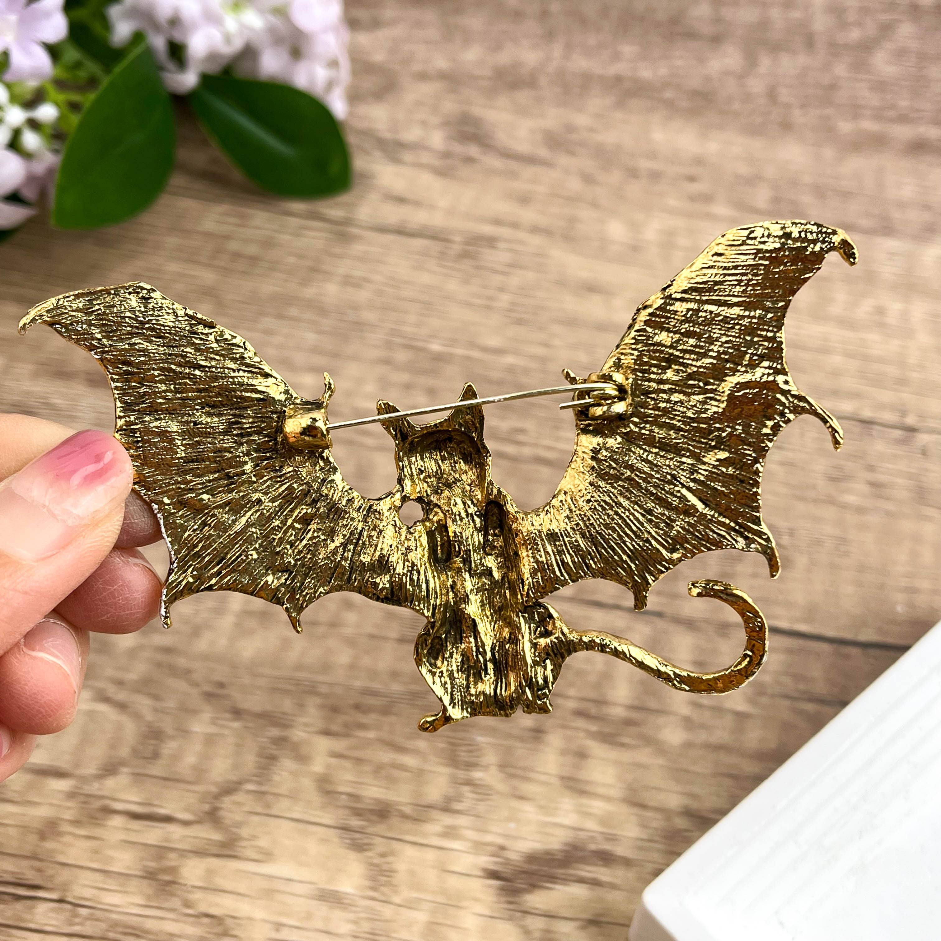 Back view of bat-shaped cat brooch showing the clasp and hinge mechanism