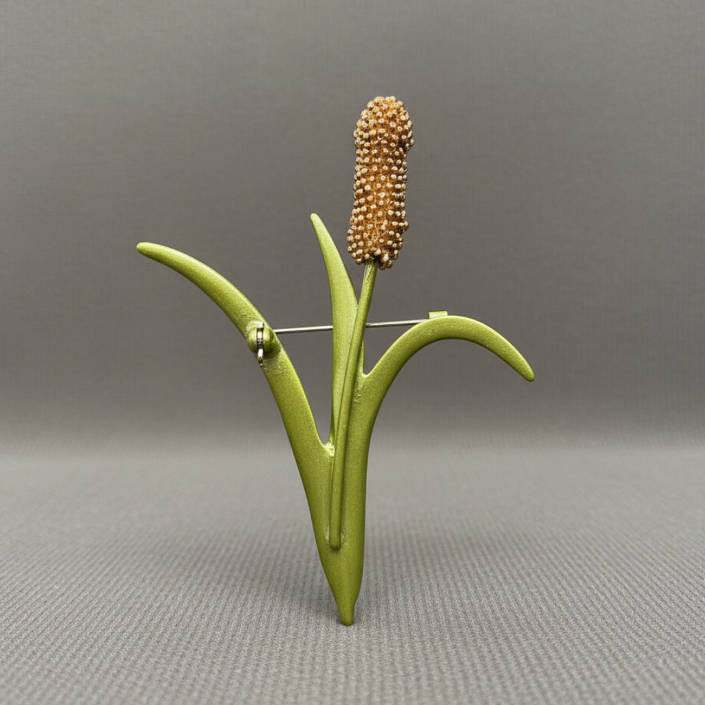 Back view of a brooch shaped like a cattail reed, showing the clasp mechanism
