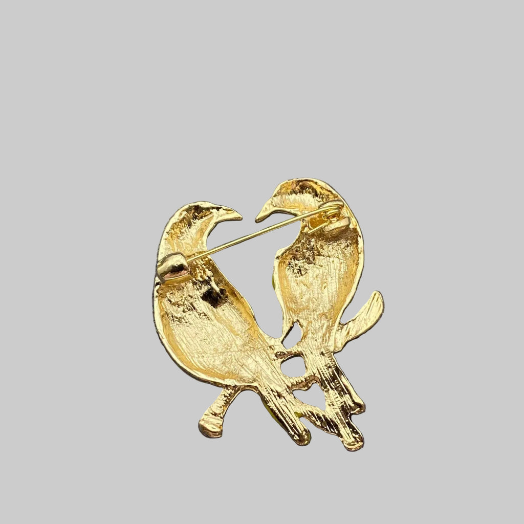 Back view of colorful bird-shaped brooch showing the clasp mechanism