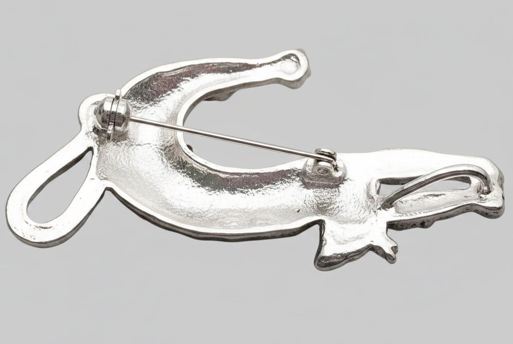 Back view of decorative cat-shaped brooch with colorful gemstones, showing the clasp mechanism