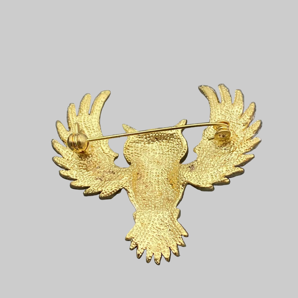 Back view of decorative owl brooch with gemstones, showing the clasp mechanism