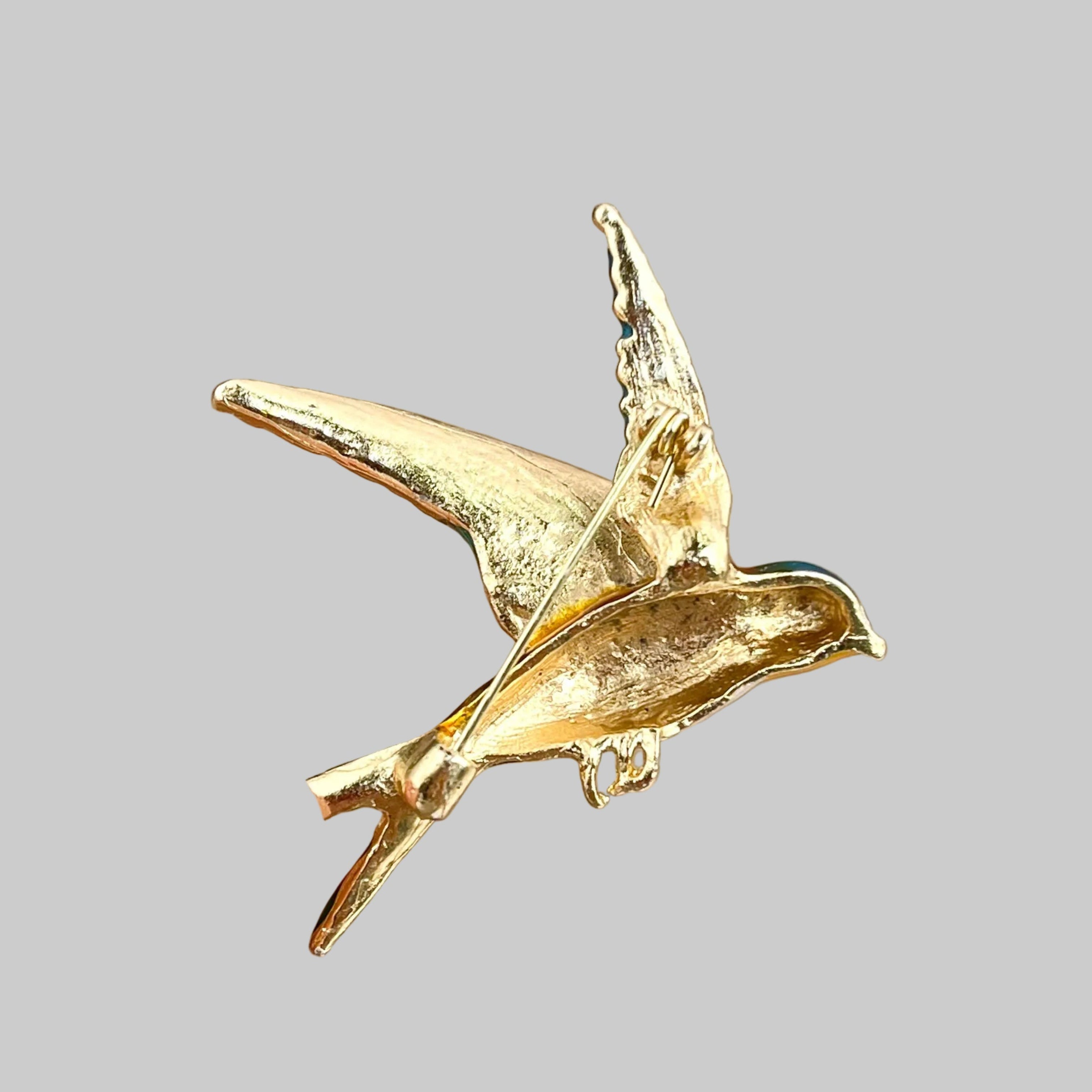 Back view of colorful bird-shaped brooch showing the clasp mechanism