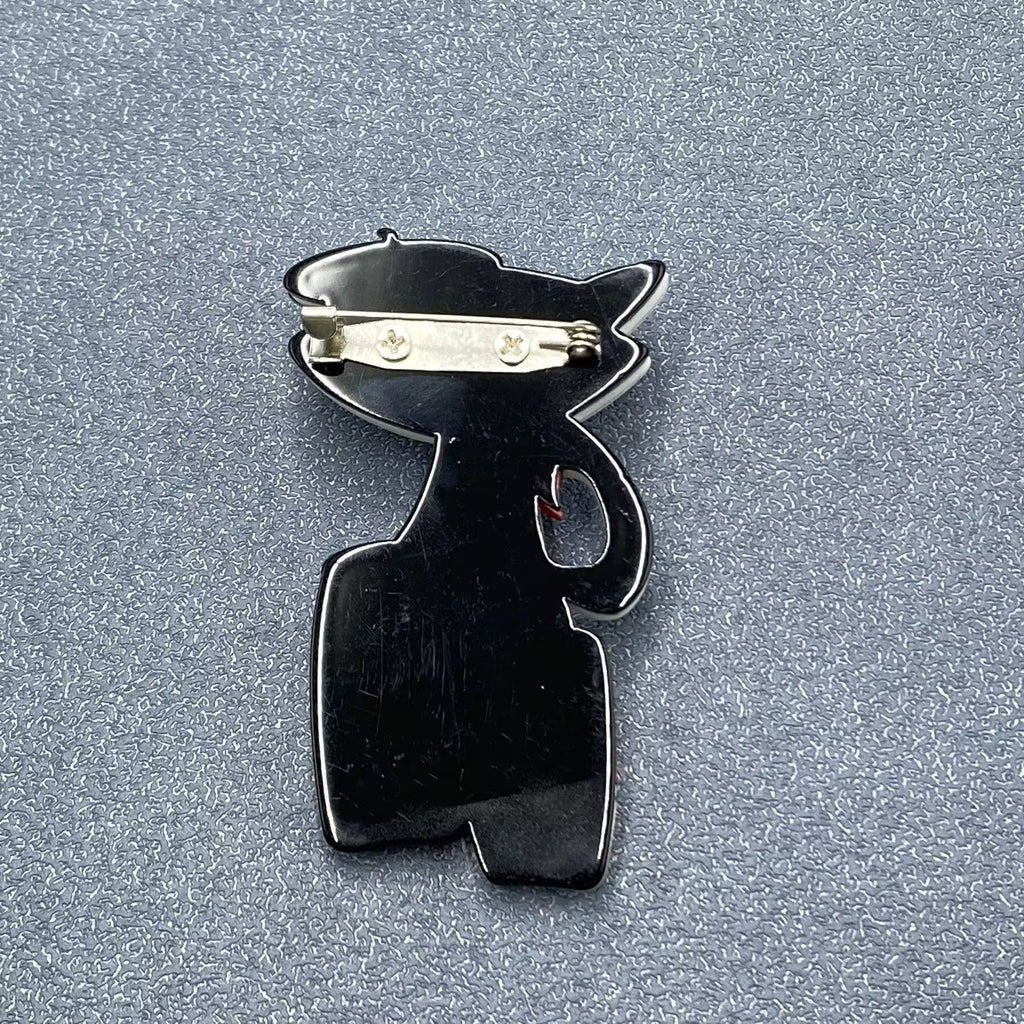 Back view of acrylic cat-shaped brooch with drums showing the clasp mechanism