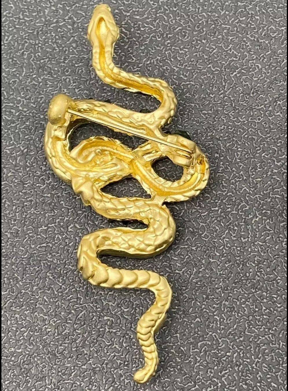 Back view of gold snake-shaped brooch pin showing clasp mechanism