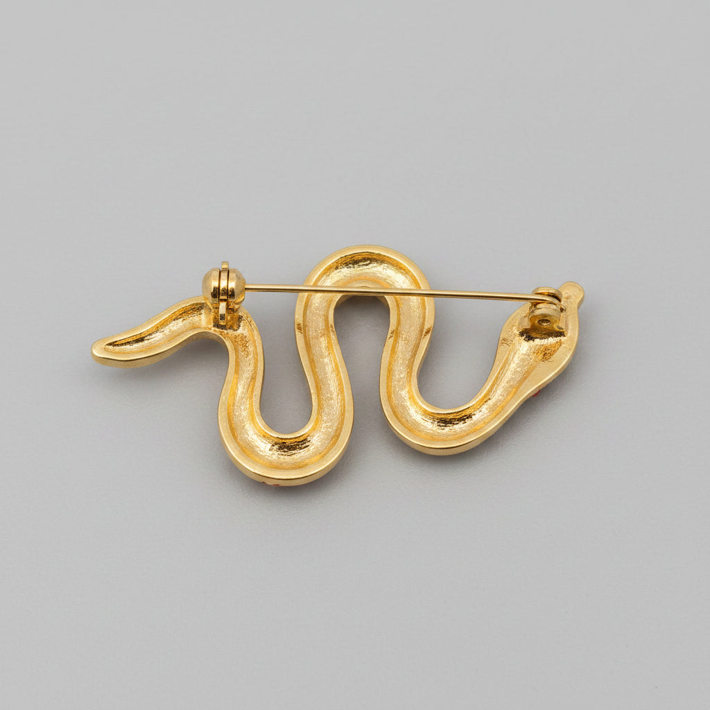 Back view of snake-shaped brooch with green and gold details, showing clasp mechanism 