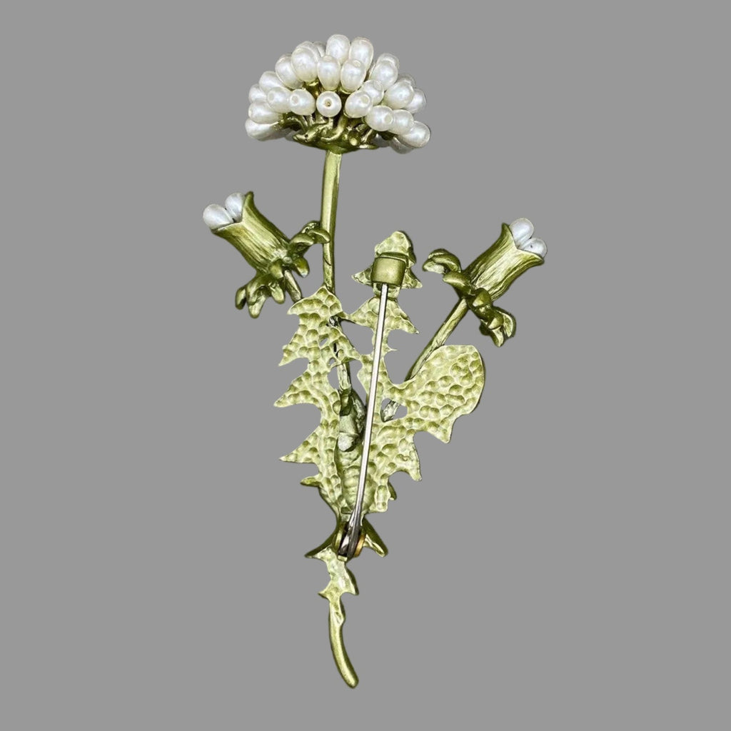 Back view of dandelion brooch with pearl-like accents, showing the clasp mechanism