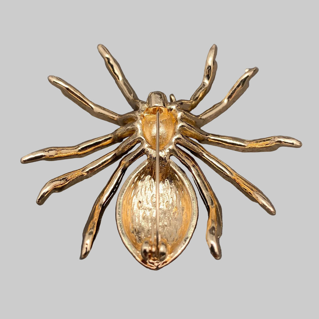 Back view of spider-shaped brooch with gold, red, and black details, showing the clasp mechanism
