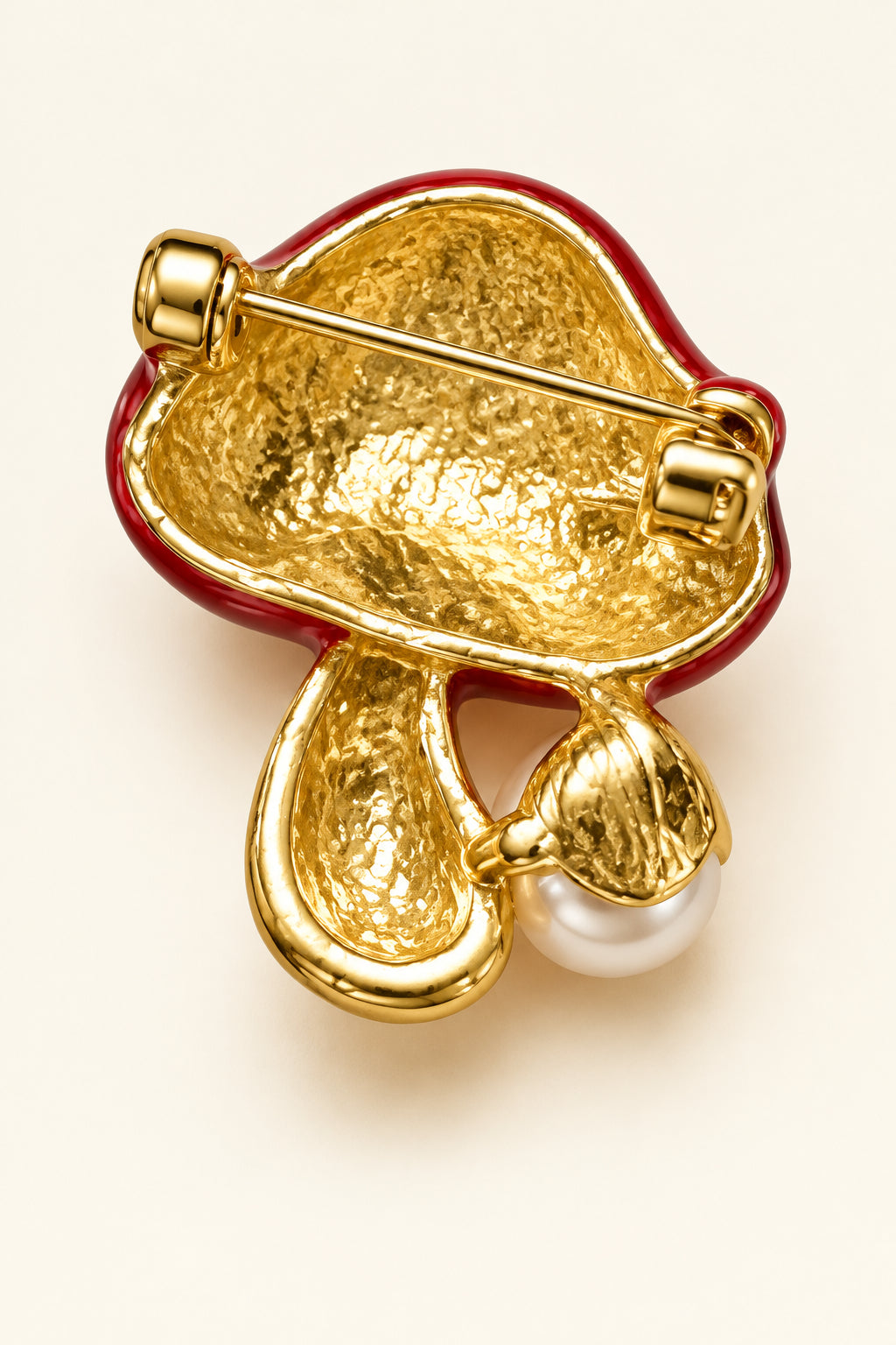 Back view of a mushroom brooch with a pearl accent, showing the clasp mechanism.