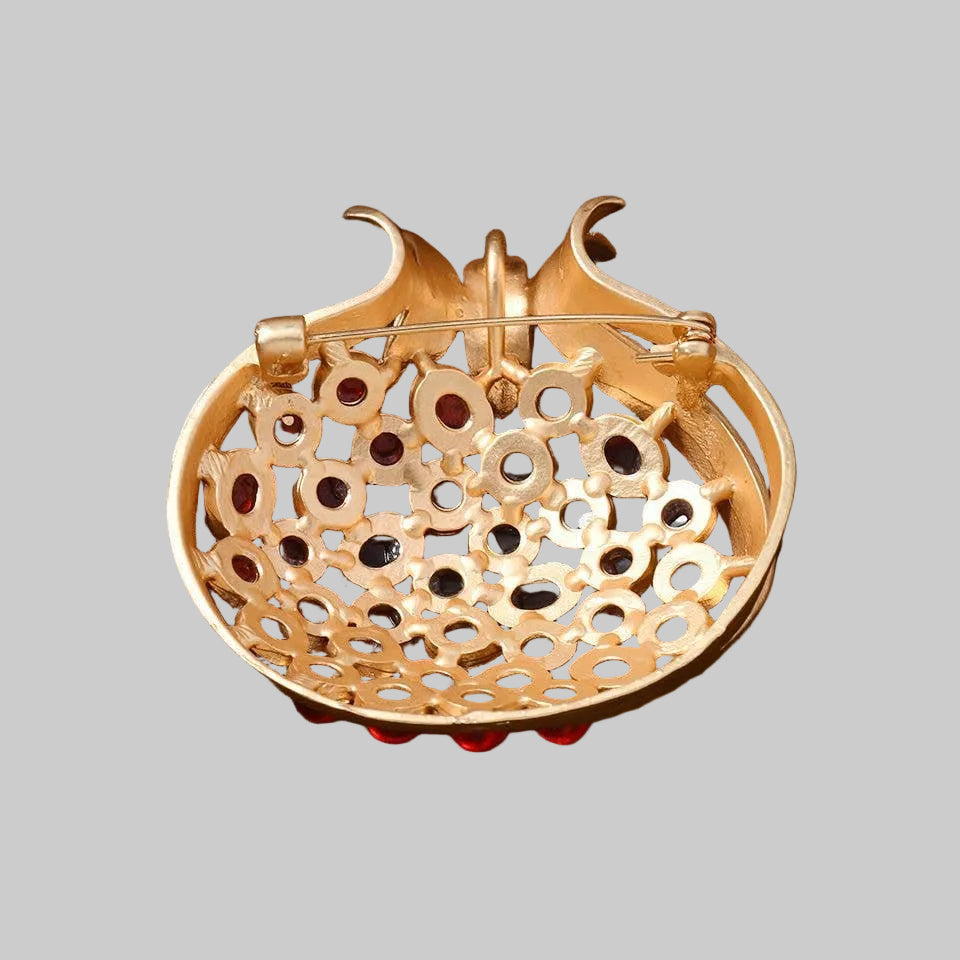 Back view of  gold-toned brooch shaped like a pomegranate, showing the clasp mechanism