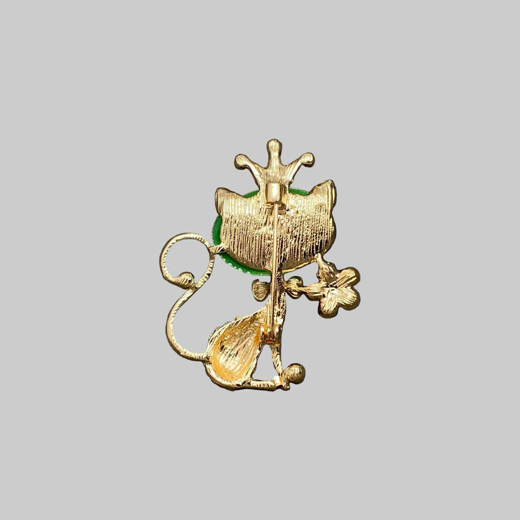 Back view of cat-shaped brooch with green gemstone and crown, showing the clasp mechanism 