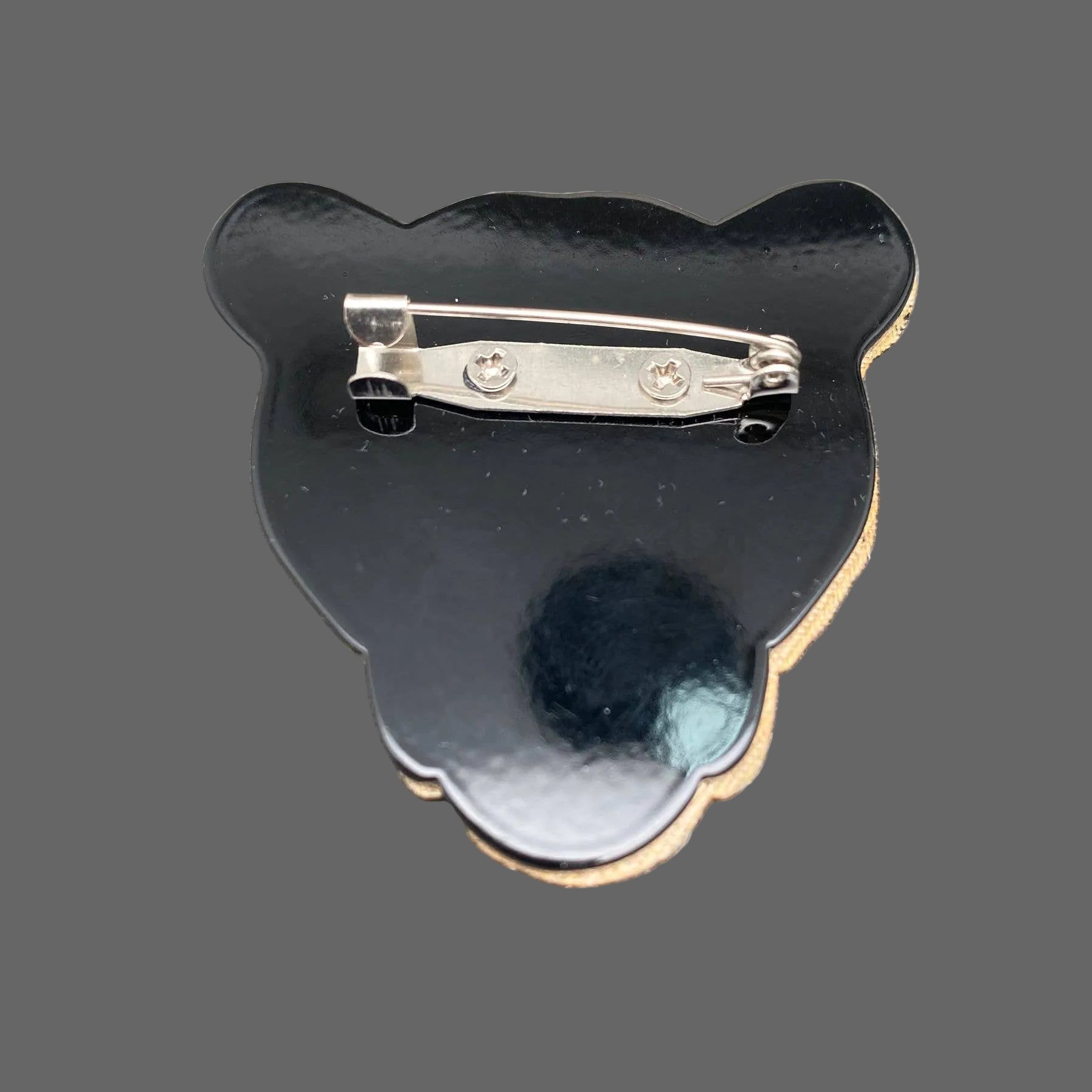 Back view of textured acrylic leopard shaped brooch showing clasp mechanism