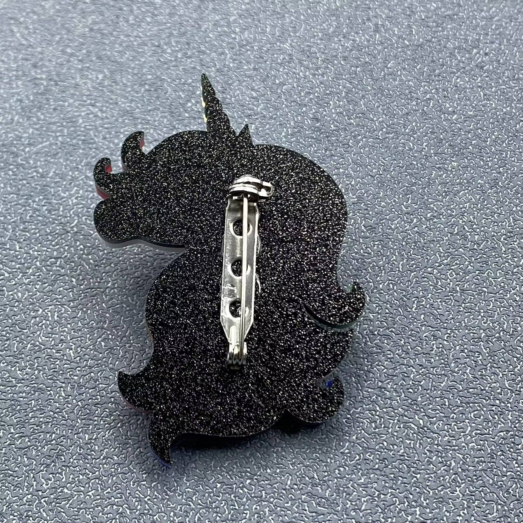 Back view of unicorn pin with multicolored mane and tail, showing clasp mechanism