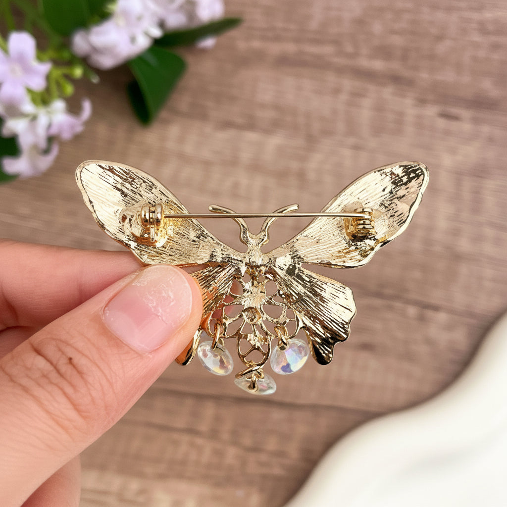 Back view of colorful butterfly-shaped brooch with gemstones, showing clasp mechanism
