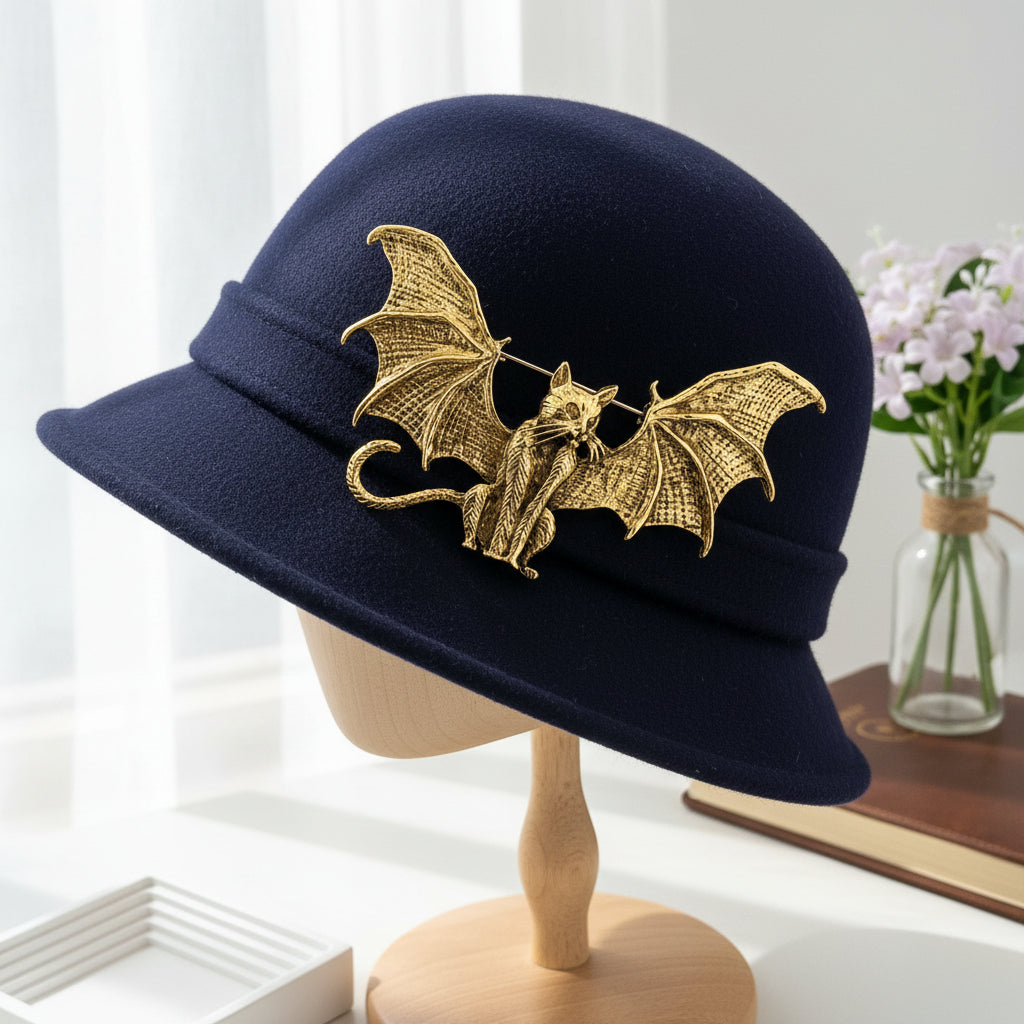 Gold metal bat-shaped brooch featuring a cat adorned with dimensional bat wings