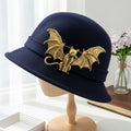 Gold metal bat-shaped brooch featuring a cat adorned with dimensional bat wings