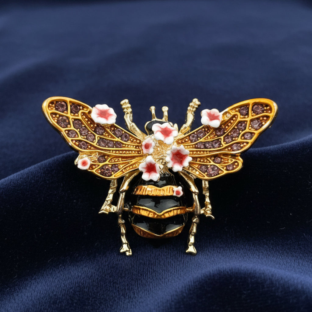 Decorative bee brooch with floral details on a blue velvet background