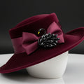 Black swan-shaped brooch pinned on a red velvet hat