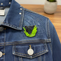 Black panther head on a green leaf brooch pinned on a denim jacket