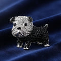 Black and silver dog-shaped brooch with gemstones on a blue background