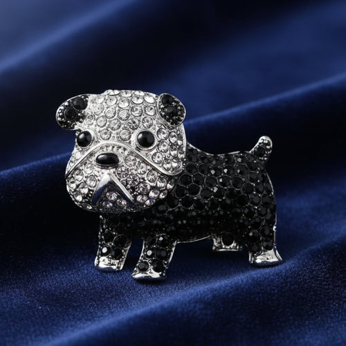 Black and silver dog-shaped brooch with gemstones on a blue background