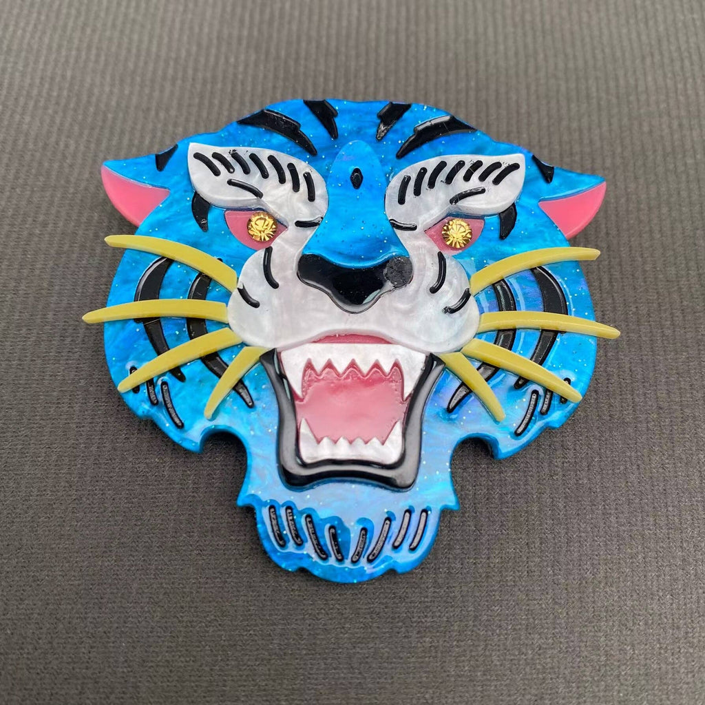 Colorful acrylic tiger head brooch on a gray background