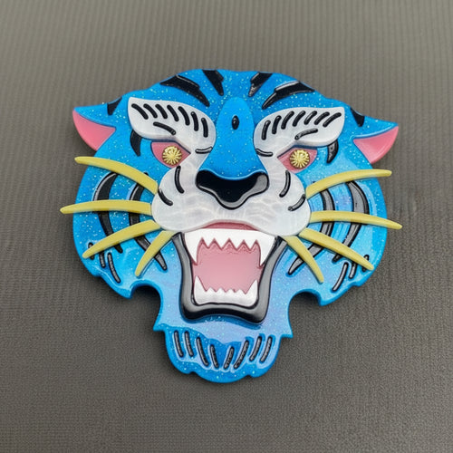 Colorful acrylic tiger head brooch on a gray background