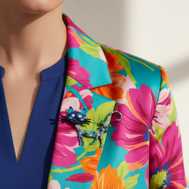 Colorful cat-shaped brooch with polka dot design pinned on a colorful dress