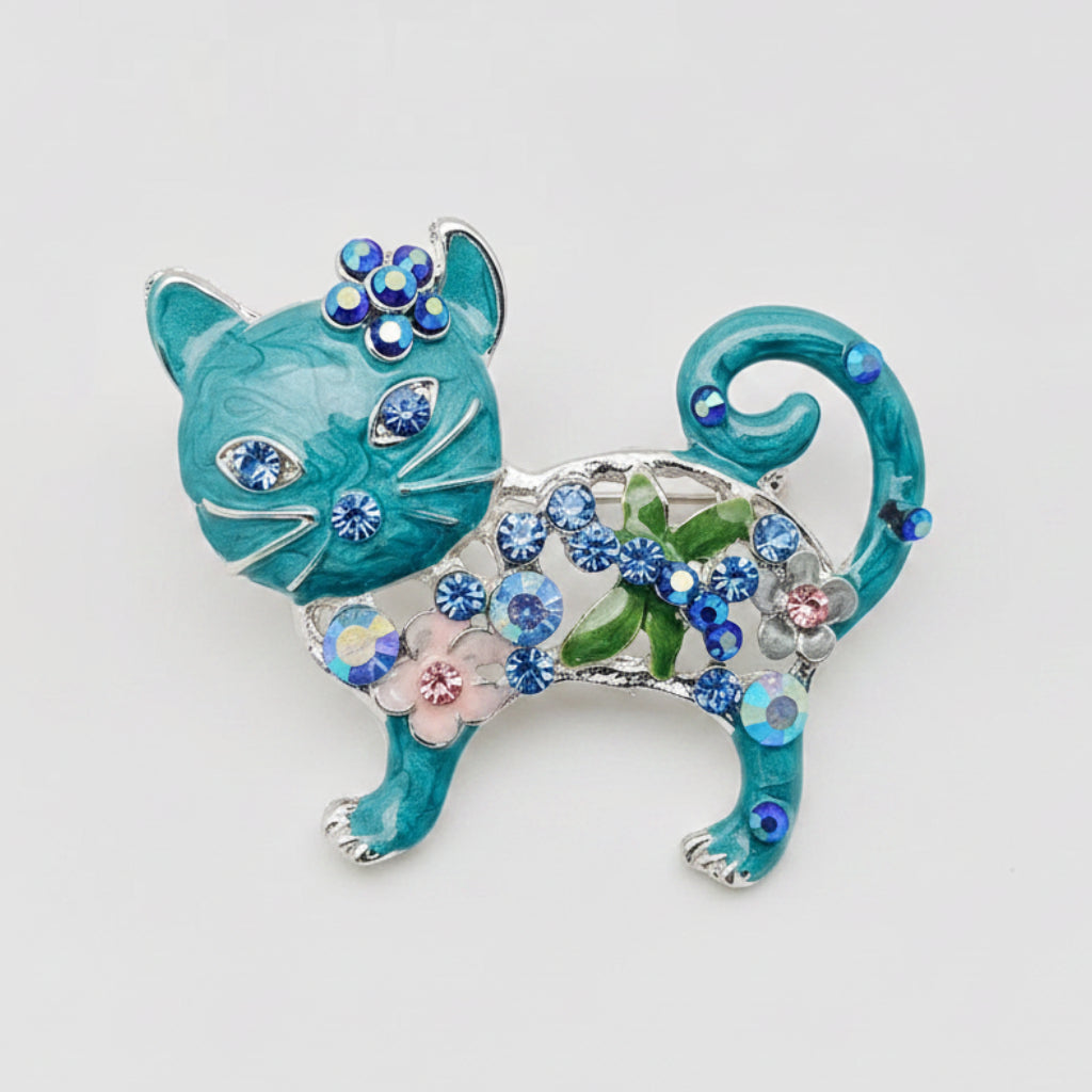 Blue cat-shaped brooch with gemstones against a gray background