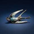 A swallow-shaped brooch with black, white, and blue enamel details and clear rhinestone accents on the wings, shown on a blue background