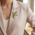 Brooch shaped like a cattail reed pinned on a linen suite
