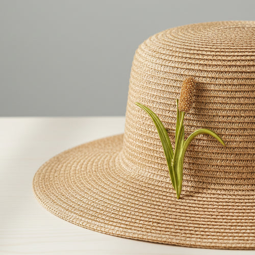Brooch shaped like a cattail reed pinned on a straw hat