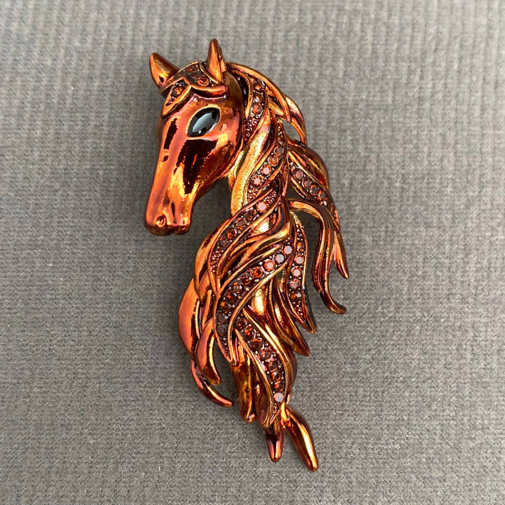 Brown horse head brooch on a gray background