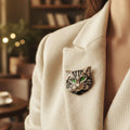 Acrylic cat-shaped brooch with green eyes pinned on a woman's beige suit