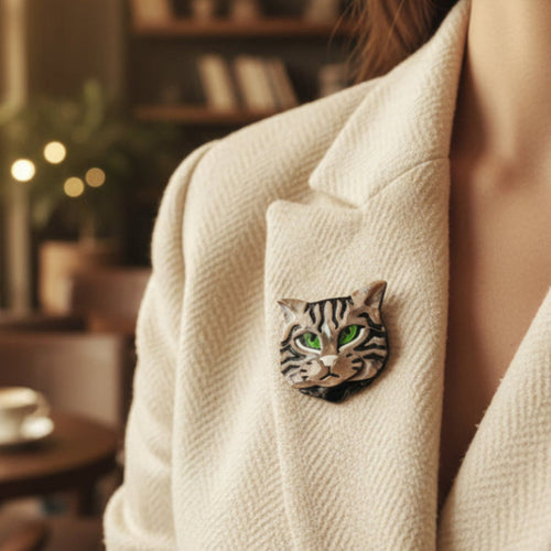Acrylic cat-shaped brooch with green eyes pinned on a woman's beige suit