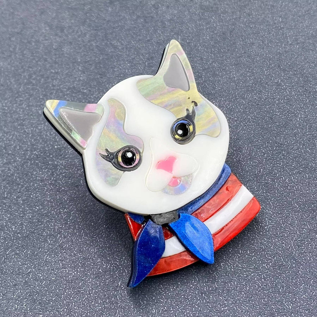 Cat-shaped brooch with a colorful design on a gray background