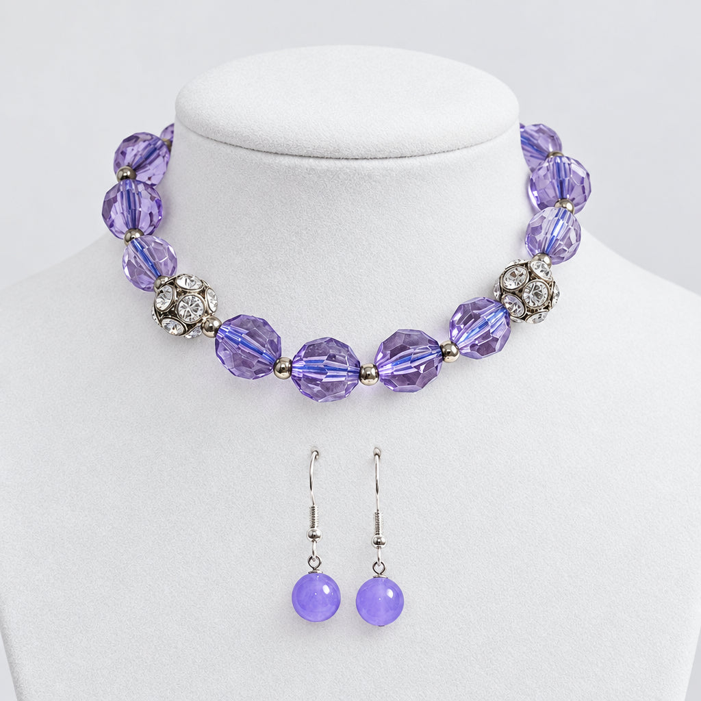 A jewelry set displayed on a cream fabric mannequin bust, featuring a beaded bracelet with faceted purple beads, silver-toned floral accents, and matching purple beaded drop earrings.