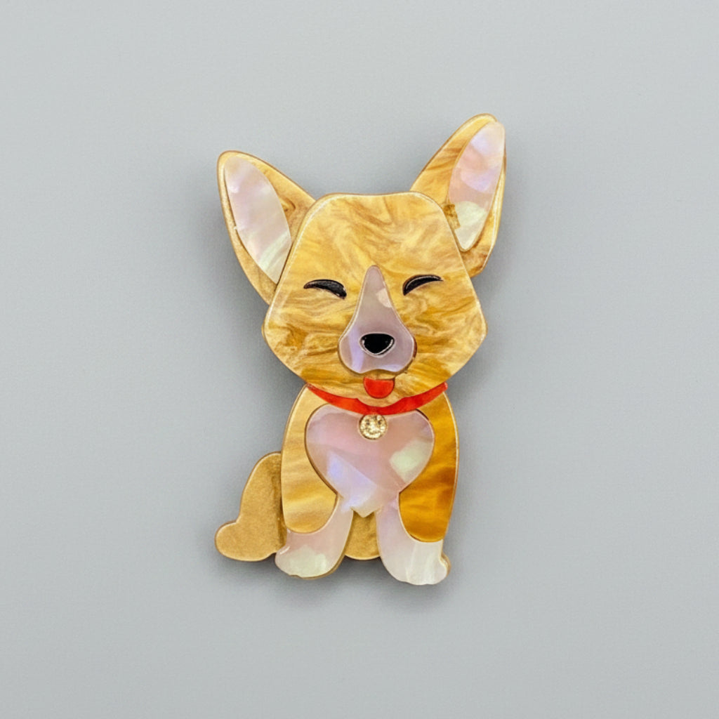 Dog-shaped brooch with a red collar on a gray background