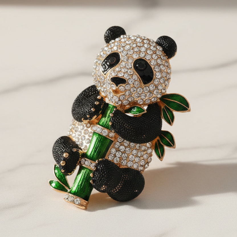 Panda-shaped brooch with gemstones on a white background
