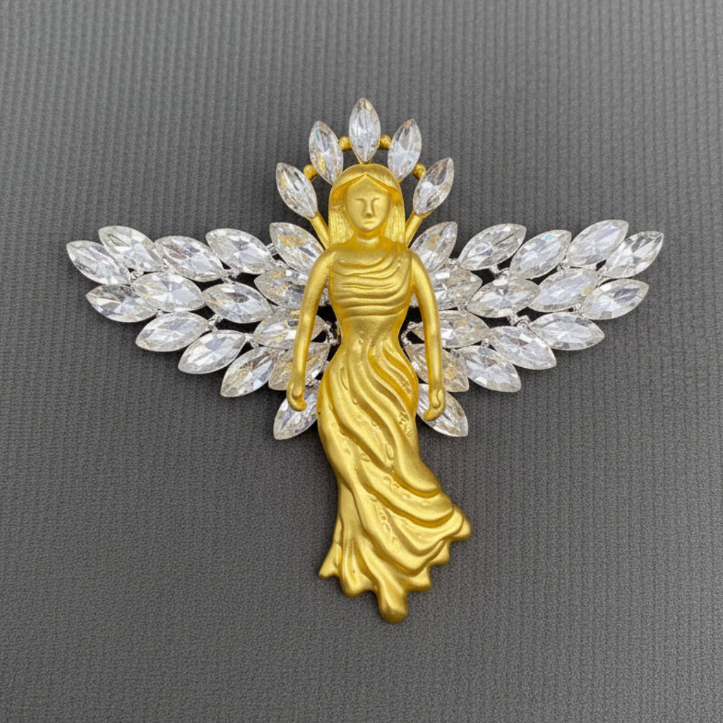 Gold angel brooch with crystal wings on a gray background