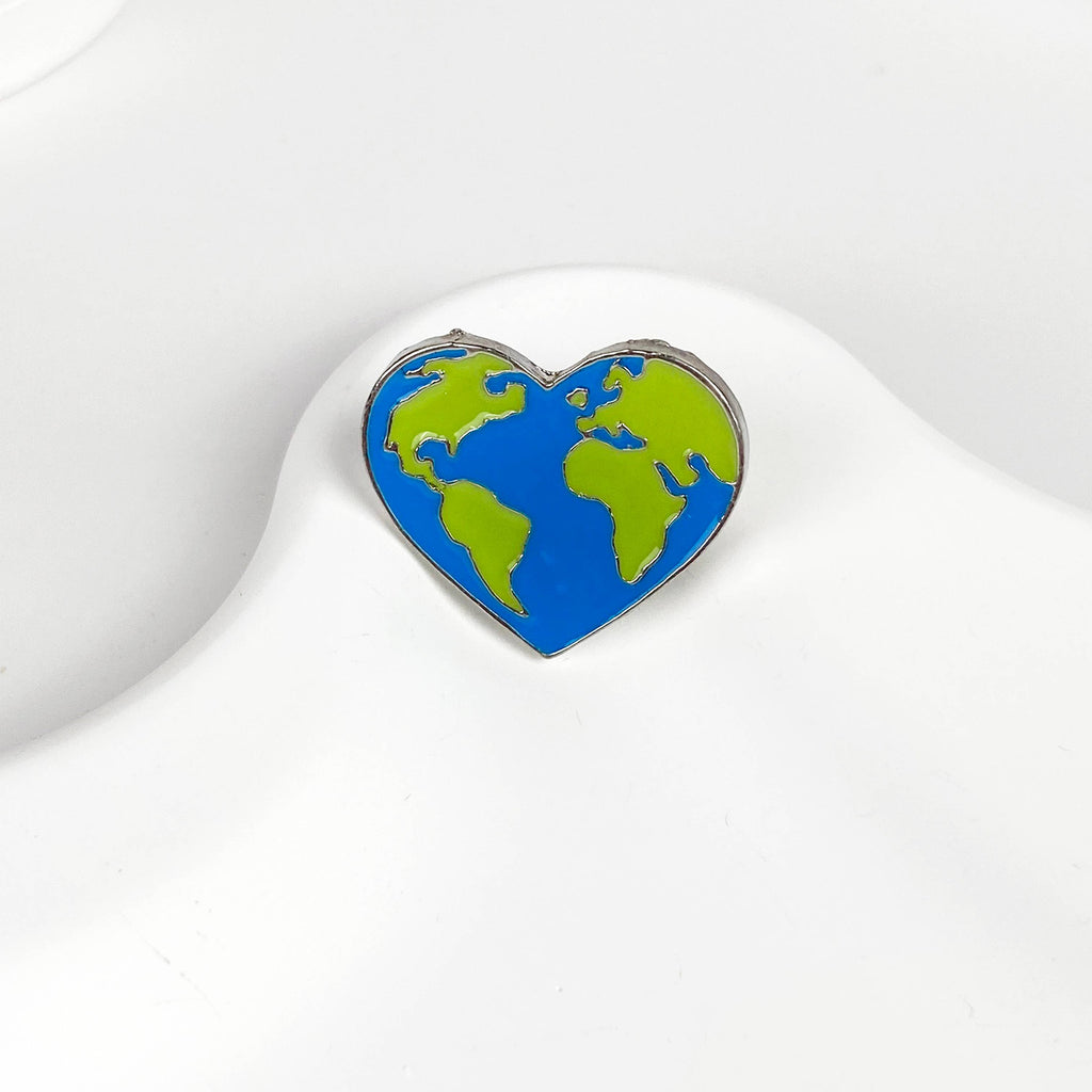 Blue and green heart-shaped earth pin on a white background