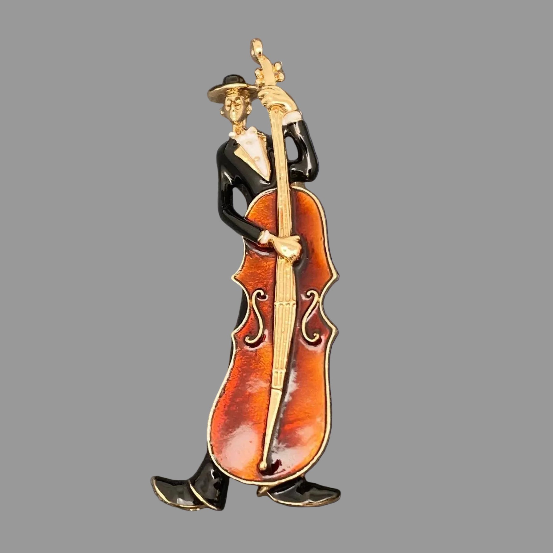 Decorative pin of a musician playing a cello on a gray background