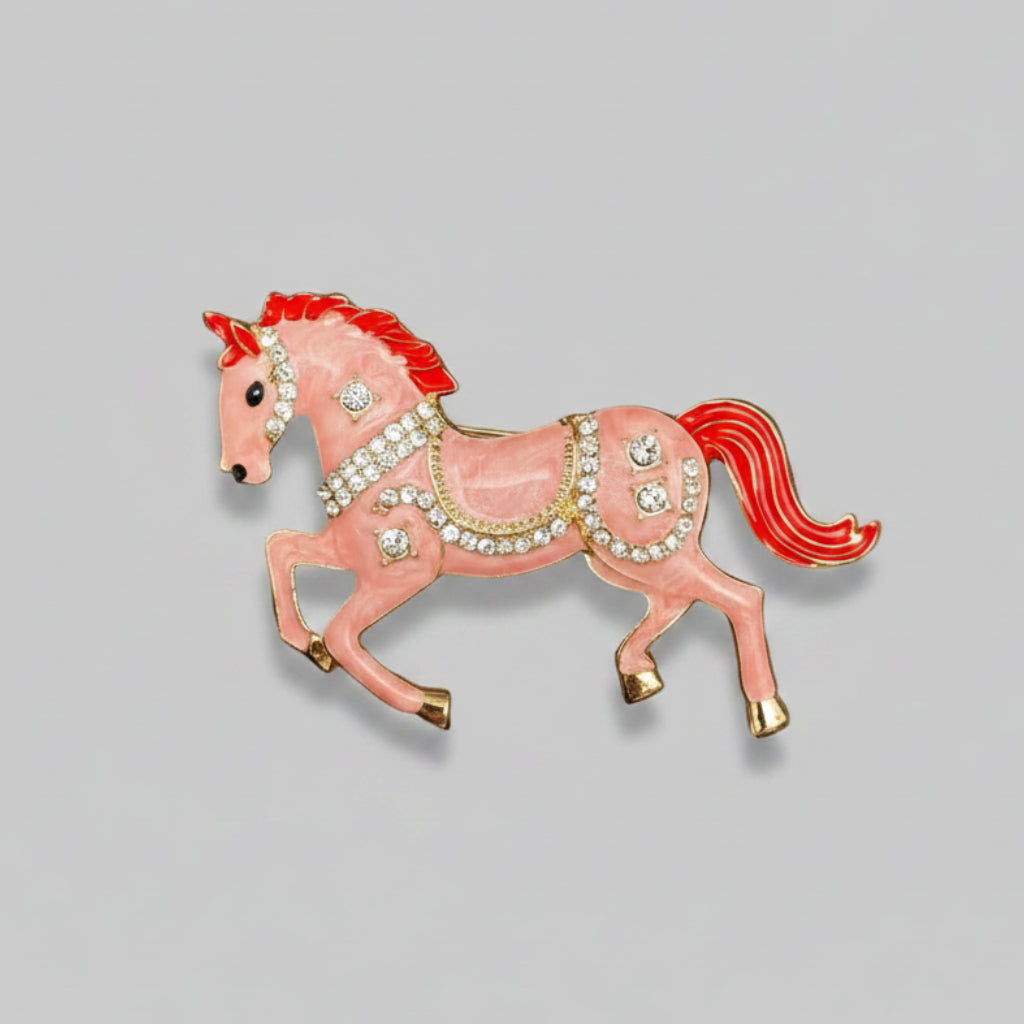 Pink horse-shaped brooch with red mane and tail, against a gray background