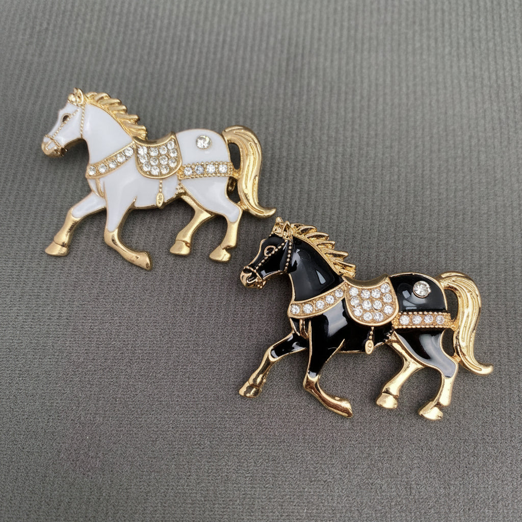 Two horse-shaped brooches, one white and one black, on a gray background