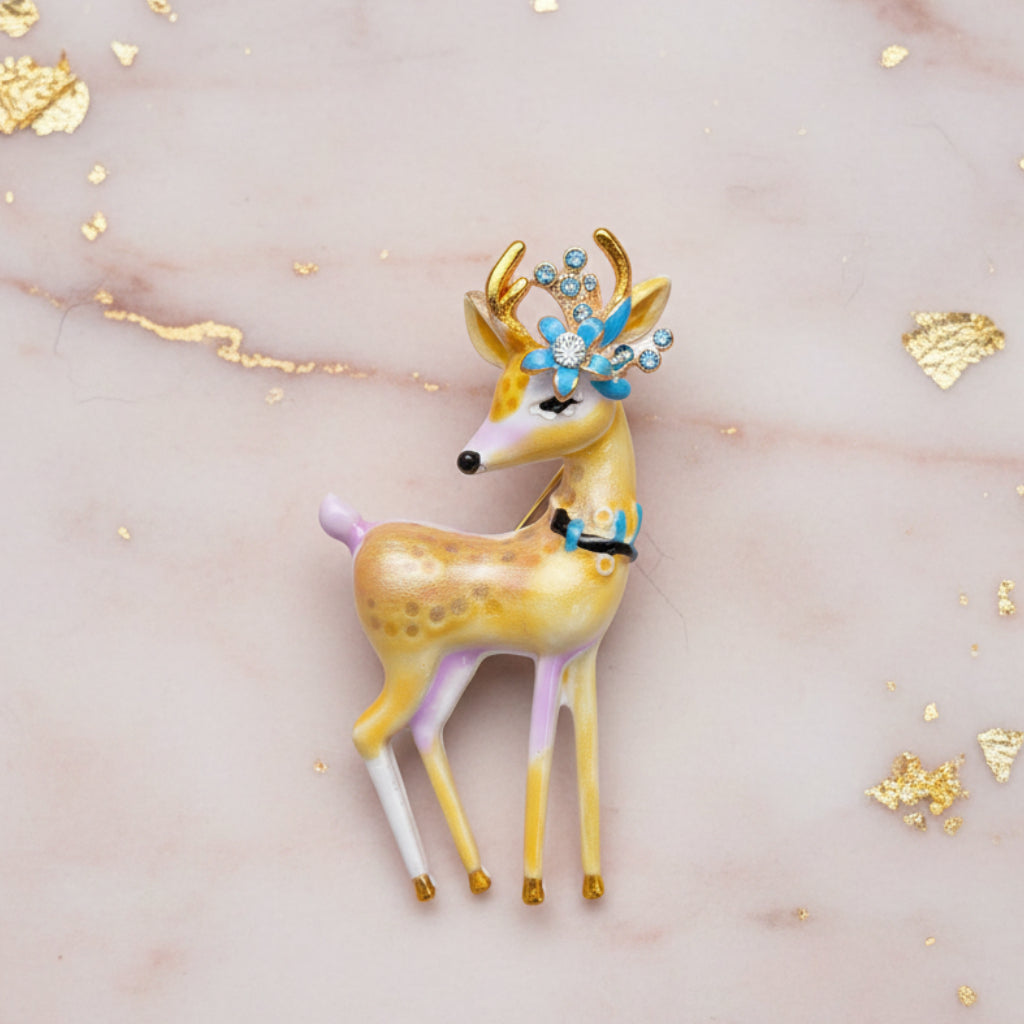Colorful deer-shaped brooch with floral antlers on a textured surface